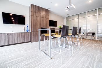 a bar with chairs and a table in a room with a tv at The Foundry, South Bend, 46617